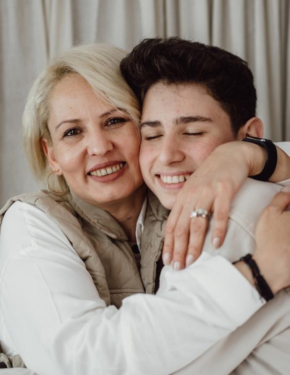 Mom hugging teenage son.