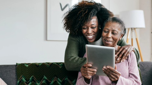 Caregiver with older woman holding tablet