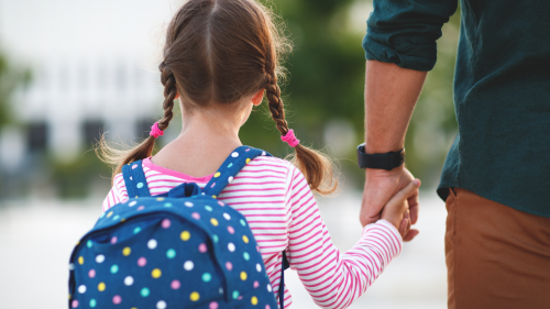 Child with backpack and parent