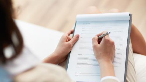 woman writing in health records