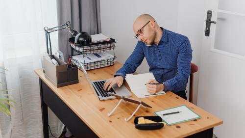 Man sitting at his desk on the phone.