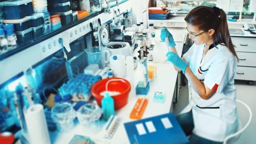 Woman pipetting in a research laboratory.